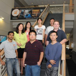 Lab members posing together on a staircase