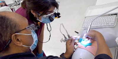 Two students work on a patient model at a simulation lab workstation