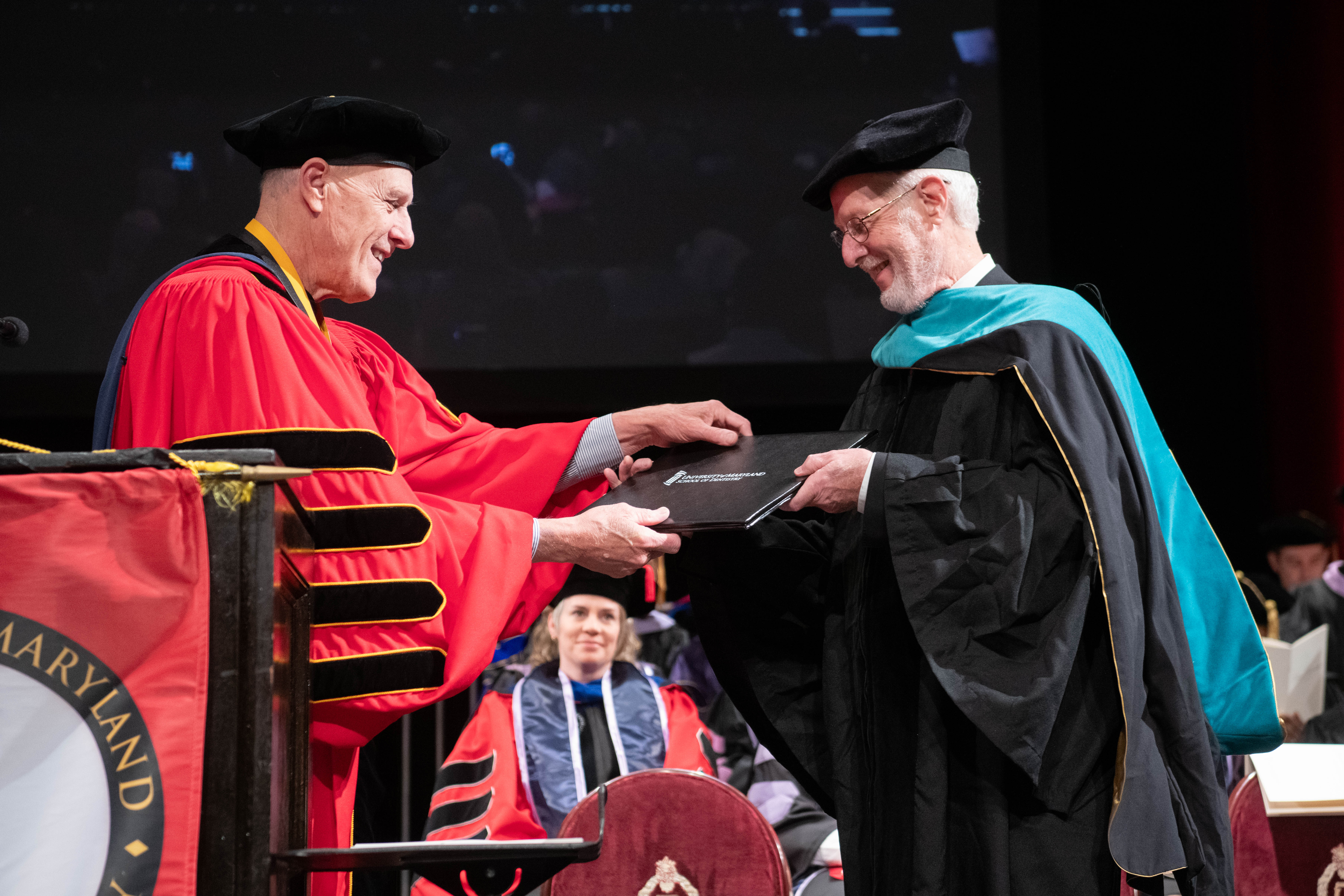 Bruce E. Jarrell, president of the University of Maryland, Baltimore, presents Robert E. Morris, with an Honorary Doctor of Public Service degree in recognition of his five-decade commitment to providing care to vulnerable populations around the world.