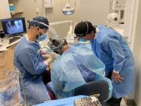 A student and teacher perform a dental procedure on a patient
