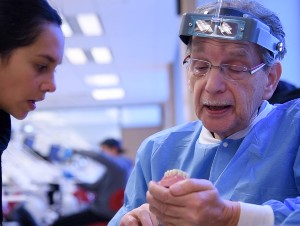 An instructor provides a dental student with guidance in the simulation lab