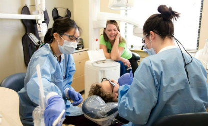 UMSOD volunteers work on patient in Perryville clinic during Sealant Saturday