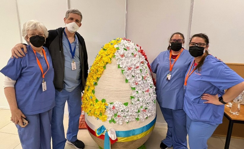 Three dentists pose with a large Easter egg in the Ukraine