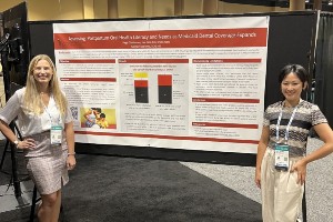 Two dental hygiene students presenting a poster