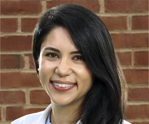 Faculty profile image of Leah Leinbach with brick background
