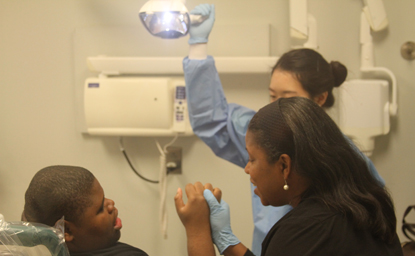 Sharon Jones, a Practice Without Pressure practice specialist, helps patient Keenan Robinson to relax during treatment in the UMSOD  Special Care and Geriatrics Clinic.