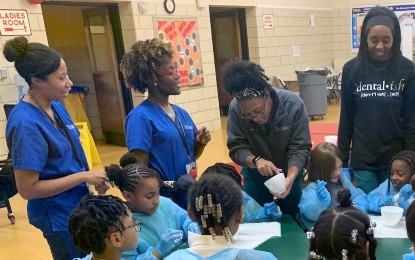 Four SNDA students at a pre-pandemic volunteering event with local students.