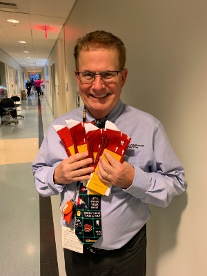 Dr. Douglas Barnes holding four pairs of colorful socks