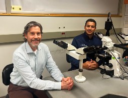 Three members of the Oral Pathology Consultants team sit around a microscope