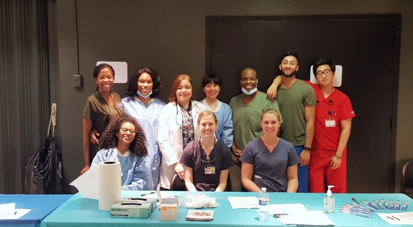 Dr. Melo poses with members of the American Student Dental Association at a Lexington Market dental screening event