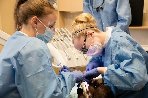 Two dentists performing orthodontic procedure
