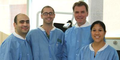 Four dental professionals in scrubs