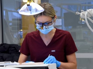 A dental student working at a simulation lab station