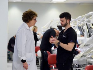 An instructor consults with a dental student