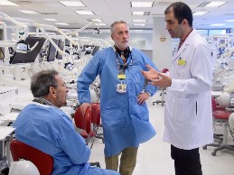 A group of dental students sits in a meeting space, waving