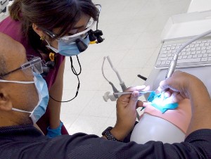 An instructor guides a dental student at a simulation lab station