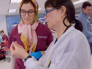 An instructor consults with a dental student in the simulation lab