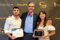 A student and teacher pose with an award