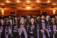 A group of graduates in cap and gown stand